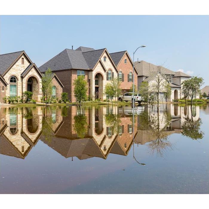 three large houses in a neighborhood with home and street flooded